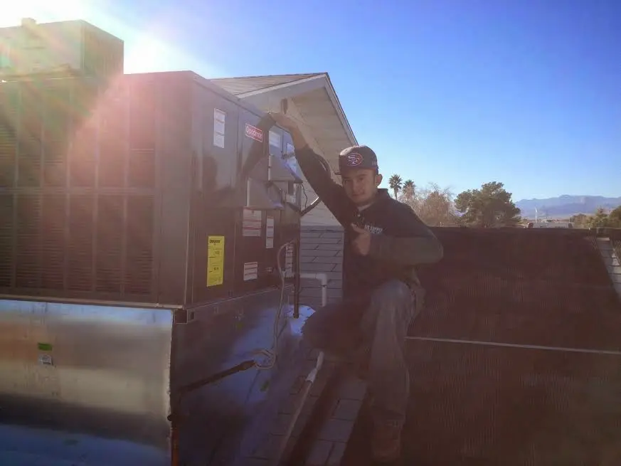 HVAC technician performing AC Tune-Up on a rooftop unit in Alsip